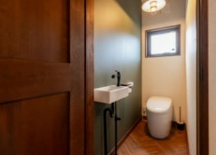 モスグリーンのアクセントクロスがお洒落なトイレ